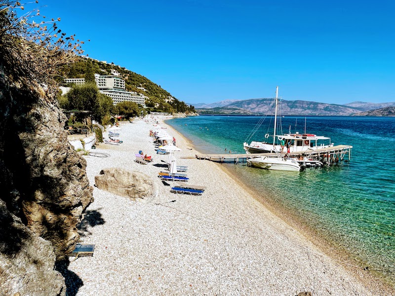 Quiet pebble beach cove on Corfu's northeast coast backed by olive groves and hills